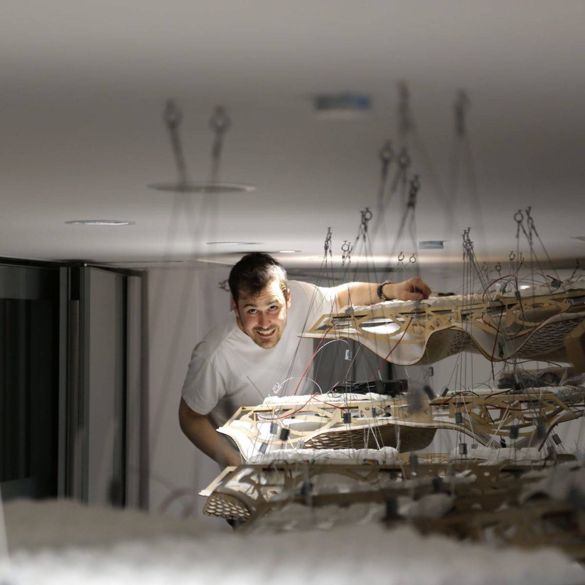 The Wooden Waves - Buro Happold - The ceiling Installation at 71 Newman Street Wiring up the steel cables and LED Strips Picture by Dr. Zoe Laughlin ©Mamou-Mani