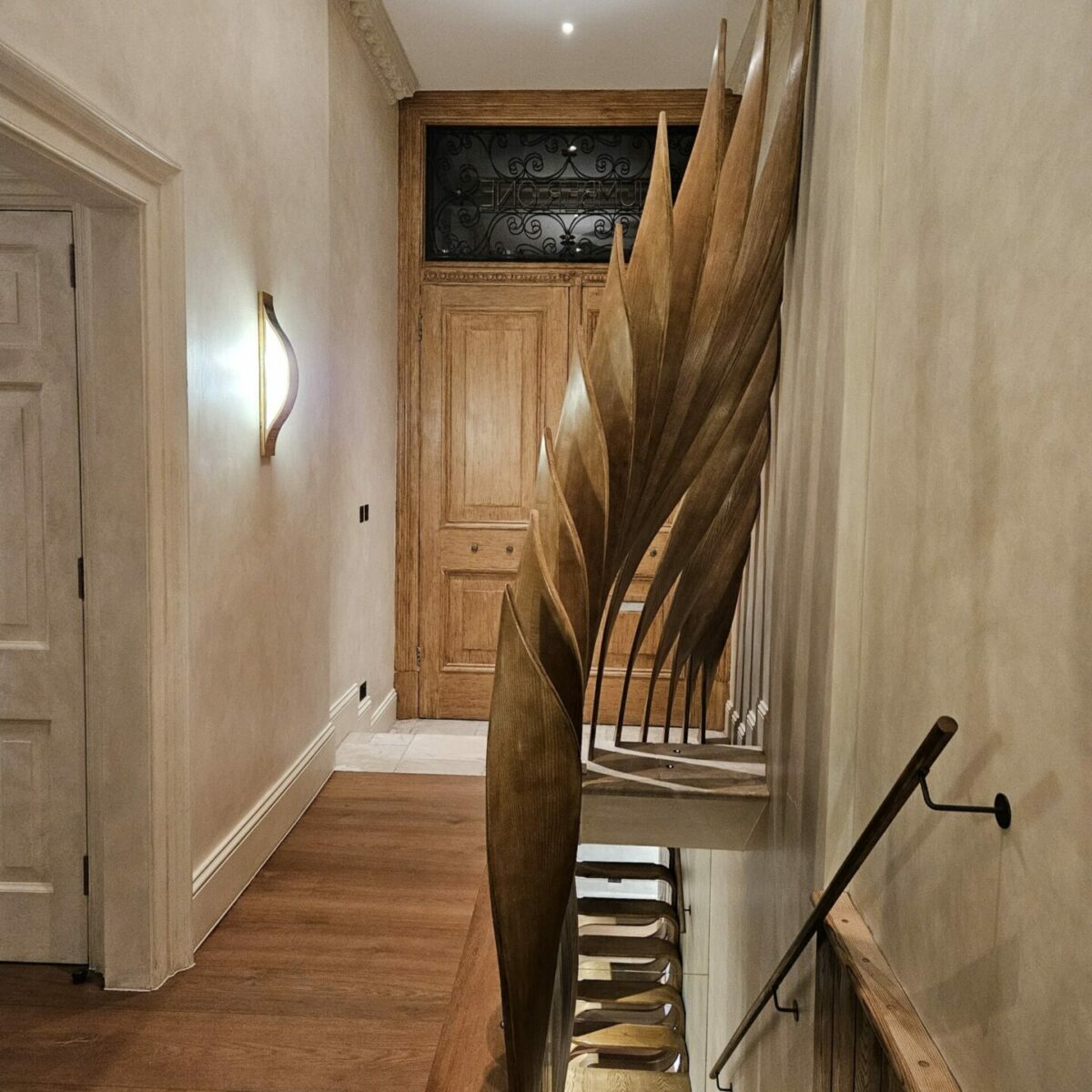 Hand-carved oak balustrade of the Rising Phoenix staircase in a London townhouse, designed by Mamou-Mani